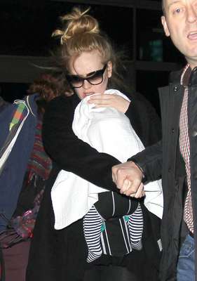 Adele teve dificuldades para fugir dos paparazzi ao desembarcar com o filho no aeroporto de Los Angeles