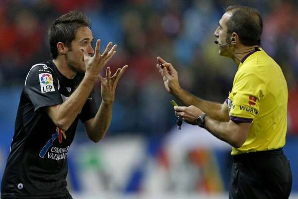 El centrocampista del Levante, Miguel Herrero "Michel" (d), protesta ante el árbitro Delgado Ferreiro, tras recibir una tarjeta amarilla durante el partido frente al Atlético de Madrid de la vigésima jornada de la liga disputado esta tarde en el estadio Vicente Calderón