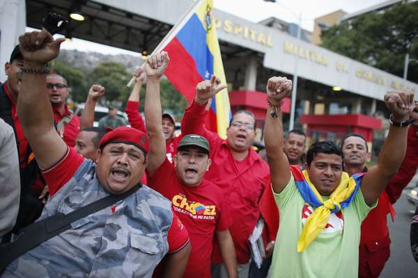 Simpatizantes do presidente venezuelano, Hugo Chávez, saúdam a chegada dele ao país em frente a hospital militar de Caracas. Chávez retornou de surpresa de Cuba nesta segunda-feira. Ele seguirá o tratamento ao cancêr no hospital militar