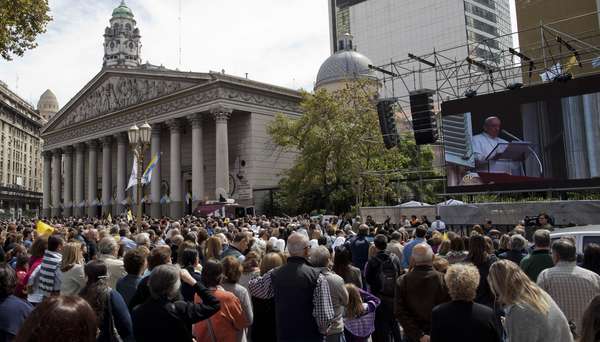 Argentinos assitem ao Ângelus, celebrado pelo Papa Francisco, em uma tela gigante instalada ao lado da Catedral Metropolitana em Buenos Aires