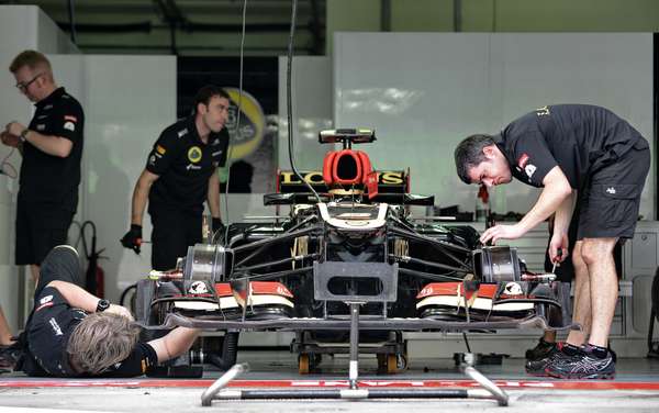 Los mecánicos de Lotus revisan el auto de Romain Grosjean a unos minutos de arrancar las prácticas en el circuito de Sepang.