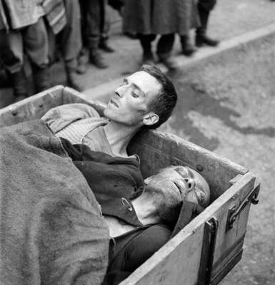 Dois prisioneiros mortos são transportados após a libertação do campo de concentração de Dachau, nas proximidades de Munique, Alemanha, em 1945. O campo de concentração de Dachau abriu em 22 de março de 1933, apenas 51 dias após Adolf Hitler se tornar chanceler alemão. Dachau foi o primeiro campo para "prisioneiros políticos" mantidos pela SS e se tornou em um modelo para os demais campos controlados pela polícia de elite de Hitler. O local permaneceu aberto até 1945, quando foi libertado por tropas americanas. Cerca de 200 mil pessoas de 38 diferentes nacionalidades foram detidas em Dachau e estima-se que 41,5 morreram ali