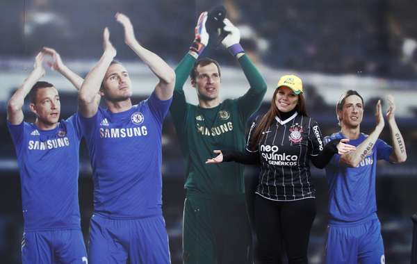 Corintiana Mariana Dante brinca com pôster com jogadores do Chelsea; torcedores brasileiros comparecem em bom número a Stamford Bridge para amistoso entre Seleção e Rússia