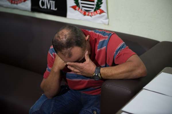 7 de maio - Pai da vítima se emociona na delegacia, onde o suspeito do crime foi apresentado nesta terça-feira após ser preso pela polícia