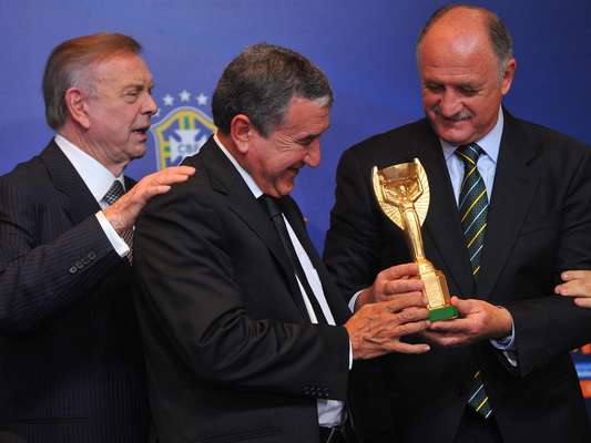 José Maria Marin (presidente da Confederação Brasileira de Futebol), Carlos Alberto Parreira (coordenador técnico) e Luiz Felipe Scolari (treinador) recebem uma réplica da Taça Jules Rimet na manhã desta terça-feira, no Rio de Janeiro. A réplica foi um presente dado por um torcedor a Felipão no dia em que o técnico anunciou os 23 convocados para defender a Seleção Brasileira na Copa das Confederações