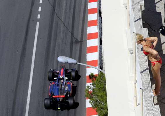 Mulher observa a passagem de Jenson Button pelo circuito urbano de Monte Carlo, no primeiro dia de treinos para o GP de Mônaco