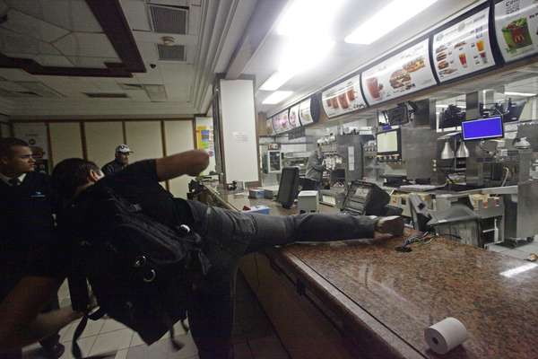 Durante protesto na noite desta terça-feira no centro de São Paulo, vândalos aproveitaram o fim do ato para praticar saques e destruir lojas e agências bancárias. Na foto, jovem depreda unidade da rede McDonald's