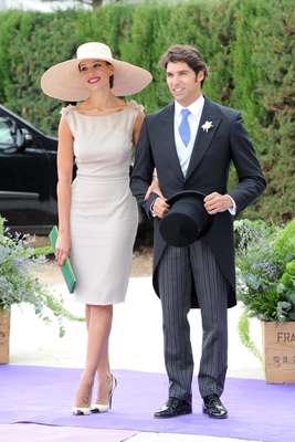 Cayetano Rivera, hermano y testigo del novio, junto a su novia, Eva González, muy elegante con un vestido en tono gris perla y pamela nude.