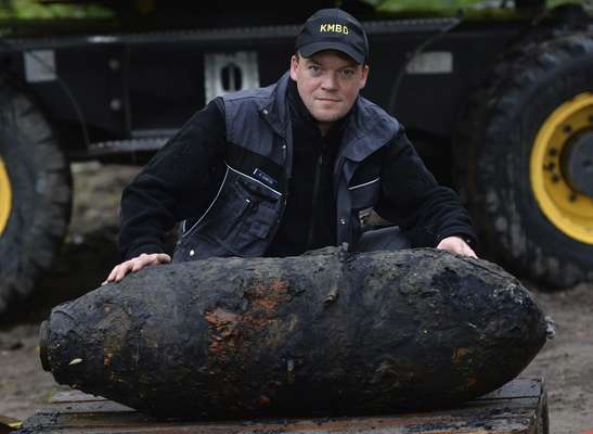 Policial alem&atilde;o posa para foto com bomba de 250 kg da Segunda Guerra Mundial encontrada na localidade de Potsdam, na Alemanha. O explosivo foi desativado nesta quarta-feira em&nbsp;uma opera&ccedil;&atilde;o que obrigou 9 mil pessoas a deixarem suas casas devido ao temor de uma explos&atilde;o