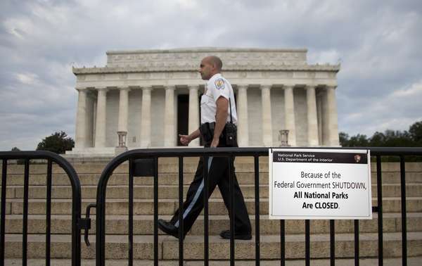 1&ordm; de outubro - Policial faz a seguran&ccedil;a atr&aacute;s de barricada com placa em que se l&ecirc; "Por causa da paralisa&ccedil;&atilde;o do governo federal todos os parques nacionais est&atilde;o fechados", em frente ao Lincoln Memorial, em Washington