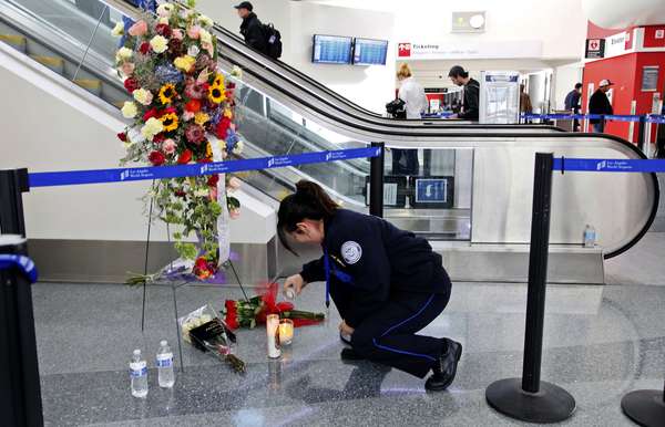 4 de novembro - A agente de segurança aeroportuária Alexa Mendoza acende vela em memorial montado em homenagem a colega morto no terminal 3 do aeroporto de Los Angeles