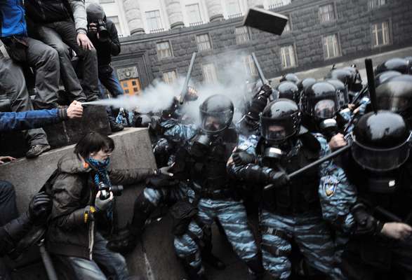 Manifestante dispara gás lacrimogêneo contra policias durante protesto em Kiev, na Ucrânia. Milhares de manifestantes de oposição protestaram nesta segunda-feira em frente ao Gabinete de Ministros Ucranianos pedindo que o governo volte atrás da decisão de desistir da adesão à União Europeia. Centenas de pessoas confrontaram a polícia