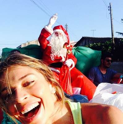 Com o paio vestido de Papael Noel, Grazi Massafera saiu pelas ruas e distribuiu presentes para crianças, na tarde desta quarta-feira (25)