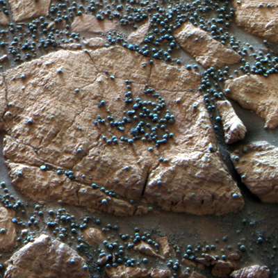 A Opportunity encontrou esse conjunto de "mirtilo" na cratera Eagle e logo analisou a composição com seus espectrômetros. Ricas do mineral hematita, essas esferas estão inseridas nas rochas marcianas como frutas em um bolo. Hipóteses sobre sua formação contribuíram para a descoberta da existência passada de água na superfície do Planeta Vermelho e indicam a existência de vida microbiana em algum momento.