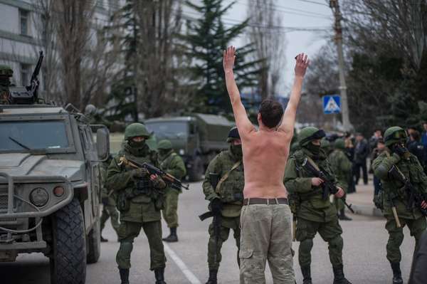 1 de março de 2014 - Homem ucraniano para em frente de tropa como forma de protesto pela 'invasão russa' ao país. Autoridades ucranianas acusaram a Rússia de enviar novas tropas para Crimeia, uma região estratégica, que abriga uma grande base naval