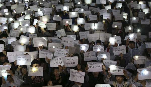 Estudantes seguram cartazes com mensagens de esperança, em memória ao seus amigos que estavam na embarcação que afundou no mar, na Coreia do Sul. Buscas continuam.