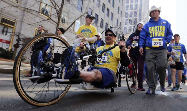 Marc Fucarile, sobrevivente que perdeu uma perna no atentado da Maratona de Boston em 2013, conduz seu triciclo de mão durante a Corrida em Tributo à maratona, neste sábado (19)