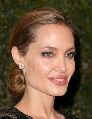A sombra marrom com o traço de delineador preto e cílios postiços harmonizam com o batom cor de boca e deixam a maquiagem de Angelina Jolie bem natural