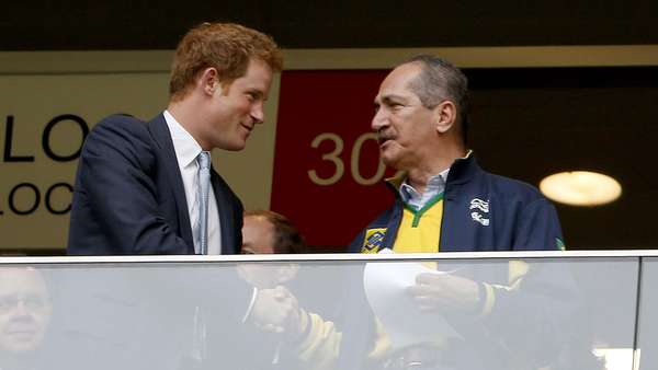 O príncipe Harry, do Reino Unido, acompanha a disputa entre Brasil x Camarões no Estádio Mané Garrincha, em Brasília, nesta segunda-feira; o integrante da família real inglesa segurou uma camisa da Seleção Brasileira e foi clicado ao lado de autoridades como Aldo Rebelo, ministro do Esporte, e José Maria Marin, presidente da CBF
