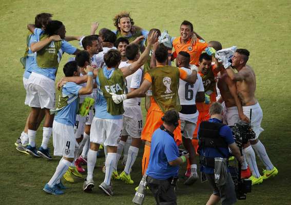 Jogadores uruguaios comemoram a classificação às oitavas de final, após vitória por 1 a 0 contra a Itália.