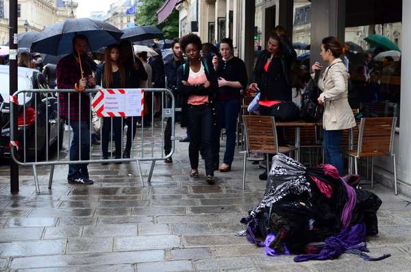 Ao lado da fila para o desfile de Jean Paul Gaultier, um grande emaranhado de tecidos se contorcia sob a chuva fina, provocando reações que iam da curiosidade à indiferença total dos convidados mais apressados