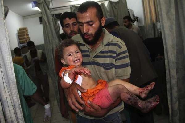 Un hombre palestino lleva a un niño herido en brazos a un hospital después de un ataque aéreo israelí sobre la localidad de Rafah, en el sur de la franja de Gaza. Alrededor de 70 palestinos murieron y 200 resultaron heridos en los bombardeos de la artillería israelí contra la población de Rafah, al sur de Gaza, en la frontera con Egipto, según fuentes oficiales palestinas, que acusaron a Israel de violar el último alto el fuego humanitario.