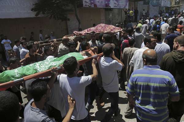 1º de agosto- palestinos carregam o corpo de uma criança e de um adulto mortos em um ataque israelense contra um edifício na Faixa de Gaza