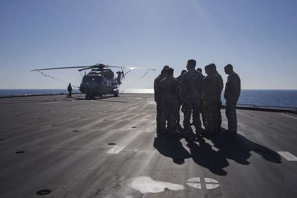 Tripulação um helicóptero se prepara para patrulhar o mar em busca de barcos carregando imigrantes. Em um espaço de seis horas, quatro barcos foram resgatados