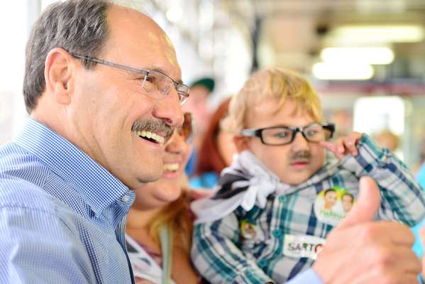 Candidato José Ivo Sartori faz foto com criança com "bigode" em vagão do Trensurb, em 9 de junho