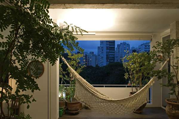 Pascali Semerdjian projeta um cantinho para relaxar com bastante verde e iluminação quente
