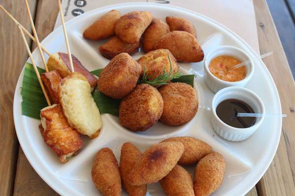 A gastronomia de Porto Seguro mistura referências mineiras e indígenas à forte identidade baiana. Na foto, entrada servida no restaurante Manito: Tábua com bolinho de batata doce com frango desfiado, bolinho de polenta recheado com carne e bolinho de abóbora com recheio de carne seca; queijo coalho, pimenta e melaço. O local é uma opção gastronômica relativamente nova na cidade. O cardápio mescla ingredientes regionais brasileiras, com referências à cozinha oriental e mediterrânea. Fica na praia de Itacimirim