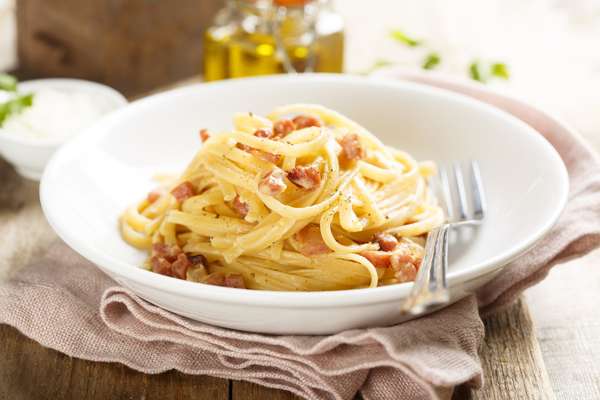 Espaguete à carbonara*Por Vitor Bourguignon Ingredientes ½ pacote de macarrão espaguete 120 g de queijo pecorino 50 g de pancetta 5 gemas Azeite Modo de preparo Coloque a água do macarrão para esquentar. Quando levantar fervura, coloque a massa e deixe cozinhar até ficar al dente. Em uma frigideira, frite a pancetta com um fio de azeite. Quando ela soltar a gordura, você coloca o macarrão na frigideira com um pouco do caldo de cozimento. Faça um creme de ovos, batendo cinco gemas com queijo pecorino ralado e pimenta do reino. Incorpore o creme de ovos ao macarrão e misture bem. A frigideira não pode estar no fogo ou então a gema irá cozinhar. Assim que formar o creme, sirva em um prato fundo.