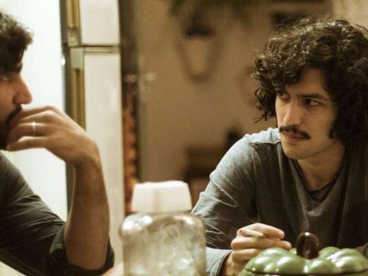 Gustavo (Gabriel Leone) se revoltará com Renato (Renato Góes) quando o irmão deixar Rimena (Maria Casadevall) sair do país na série 'Os Dias Eram Assim'