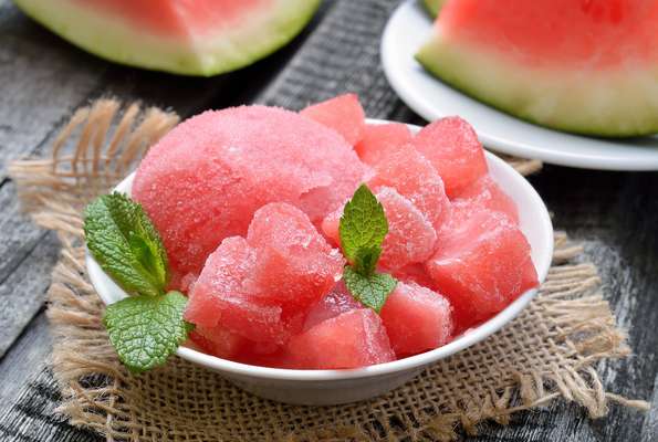 SORBET DE MELANCIA COM HORTELÃIngredientes: 1/2 xícara de açúcar 1/3 xícara de água 4 xícaras de melancia sem sementes em cubos 1 colher (sopa) de suco de limão Folhas de hortelã (para decorar) Modo de Preparo: Em uma panela pequena junte o açúcar na água e ferva por um minuto até dissolver. Retire do fogo e deixe esfriar. No liquidificador bata a melancia e o suco de limão. Acrescente a calda de açúcar e bata novamente até misturar bem. Passe por uma peneira para uma tigela, cubra com um plástico e refrigere por duas horas ou deixe de um dia para outro. Transfira a melancia gelada para uma máquina de fazer sorvete e proceda de acordo com as instruções do fabricante. Caso não tenha a máquina, transfira para um recipiente com tampa e congele. Retire do freezer após duas horas e bata no liquidificador. Torne a congelar por duas horas, retire e bata. Repita a operação até ficar cremoso ao gosto. Mantenha no freezer com tampa. Antes de consumir, transfira para geladeira por 15 a 20 minutos e sirva decorado com folhas de hortelã. A receita pode ser congelada e mantida por até dois meses no freezer.