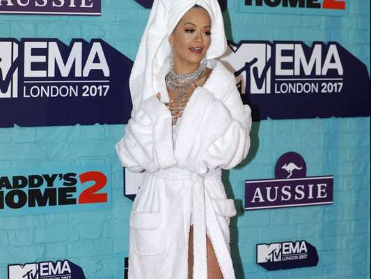 Rita Ora chama atenção por chegar de roupão de banho no EMA 2017