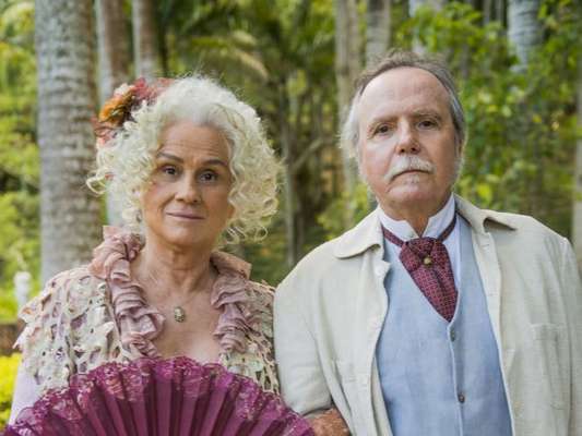 Ofélia (Vera Holtz) enfreta o marido, Felisberto (Tato Gabus Mendes), para arrumar bons casamentos para as filhas, na novela 'Orgulho e Paixão'