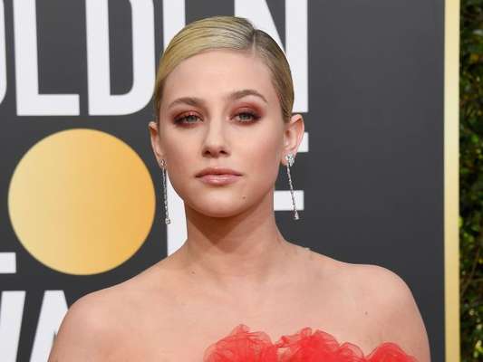 Atriz da série 'Riverdale', Lili Reinhart apostou na sombra laranja para combinar com o vestido coral no Globo de Ouro 2019