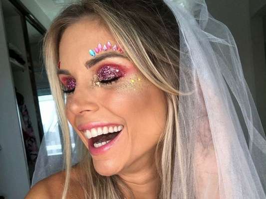 Flávia Viana apostou na sombra vermelha com muito glitter rosa por cima. Na pele, glitter dourado e aplicações de strass