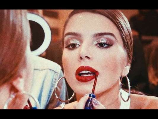 Giovanna Lancellotti passa o batom vermelho com muito cuidado nos lábios. Cor deixou o visual da atriz mais sofisticado