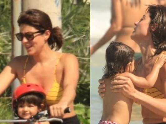 Carol Castro passeou de bicicleta e se refrescou no mar com a filha, Nina, de 1 ano