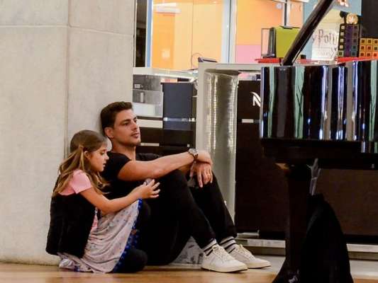 Cauã Reymond e a filha se sentam no chão para ver pianista em shopping nesta terça-feira, dia 09 de julho de 2019