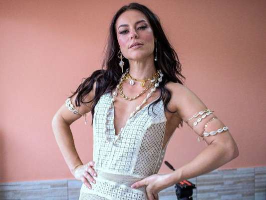 Paolla Oliveira usou vestido branco e acessórios com búzios para gravar o clipe da Grande Rio
