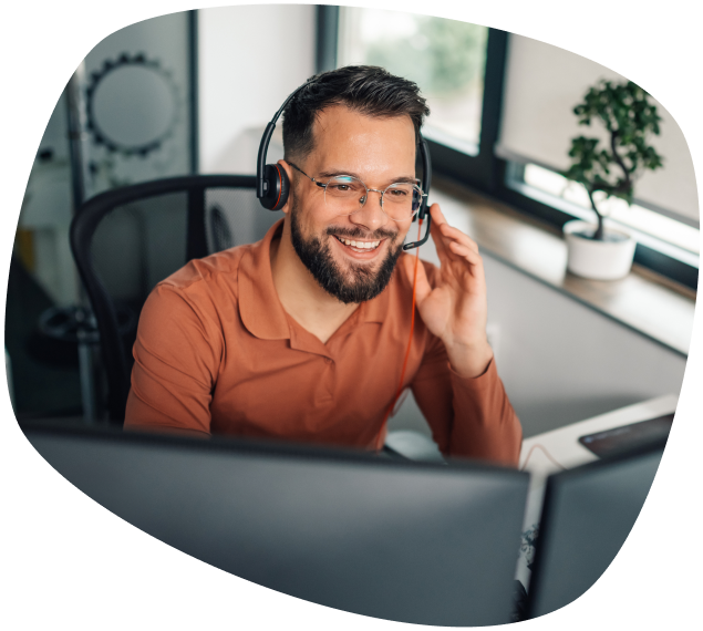 Suporte técnico onde e quando precisar homem branco com barba usando óculos e headphones em frente ao computador