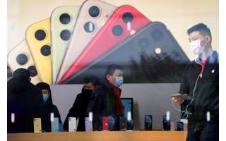 Pessoas usando máscaras de proteção circulam em loja da Apple, na China. 29/1/2020.  REUTERS/Aly Song