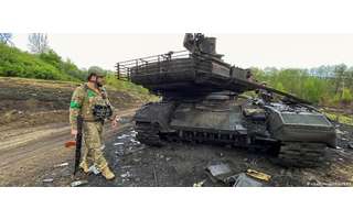 Soldado ucraniano observa tanque russo destruído na região de Kharkiv