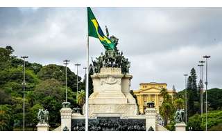 Imagem do monumento à Independência do Brasil, localizado em São Paulo. Em frente ao monumento, está erguida a bandeira do país.