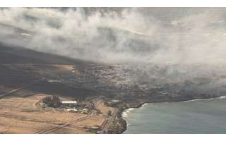 Vista aérea de edificios dañados y humo en la ciudad de Lahaina