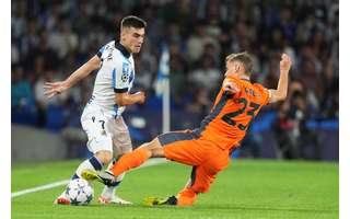 Ander Barrenetxea de la Real Sociedad y Nicolo Barella del Inter de Milán (en naranja) comparten el balón.