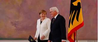 Angela Merkel (e.) segura certificado de nomeação ao lado do presidente alemão, Frank-Walter Steinmeier