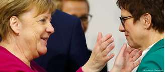 Annegret Kramp-Karrenbauer (dir.) é cumprimentada por Merkel após vitória no congresso da CDU